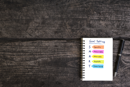 Goals vs. objectives. Picture of smart goals written on a notebook